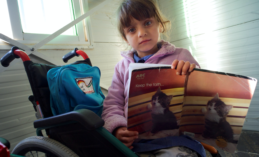 girl in wheelchair holding book