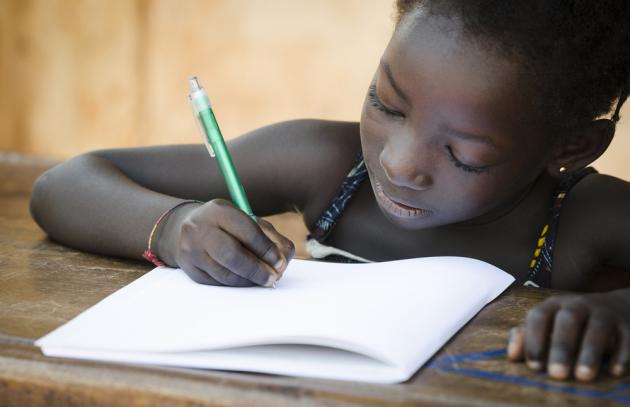 learner writing at desk