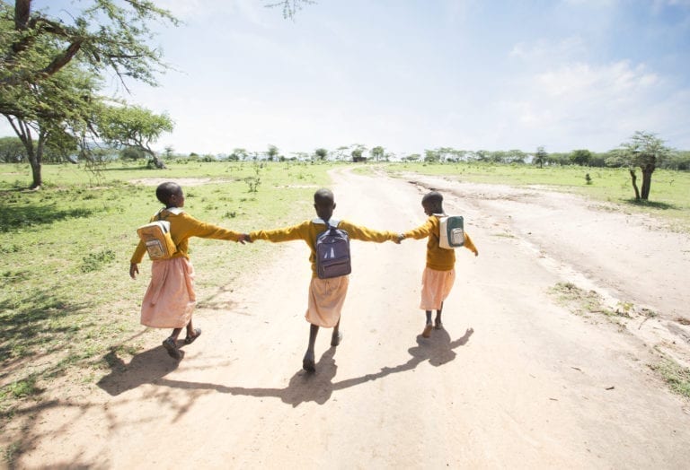 Young girls walking with backpacks on. 